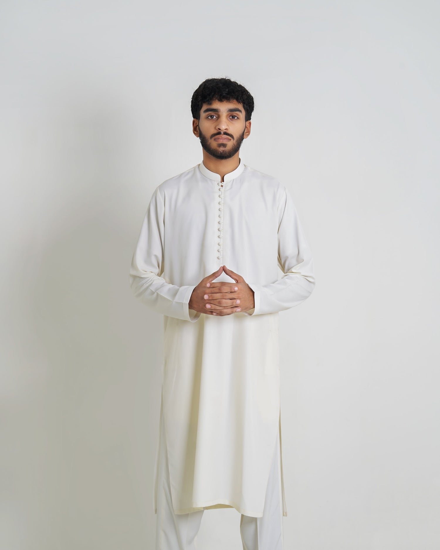 Male model wearing a traditional Pakistani white boski shalwar kameez with a straight kameez and loose shalwar, styled in premium fabric against a plain background with minimal decor.